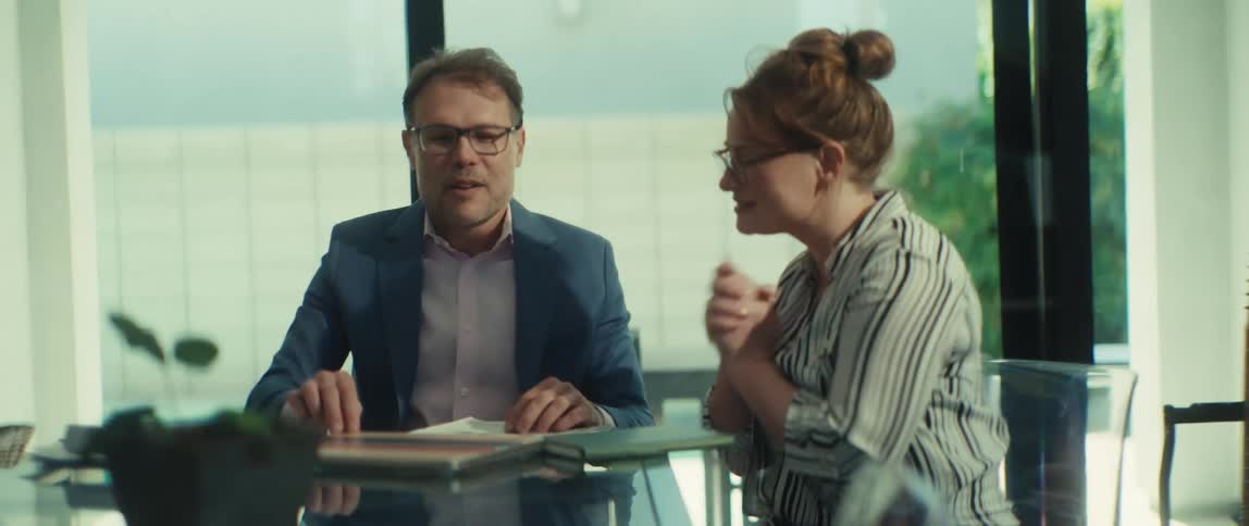 A businessman and businesswoman finalize a deal with a handshake after a successful meeting in a modern office