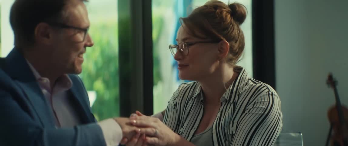 A professional man and woman happily shake hands, finalizing a successful collaboration in their bright, modern office