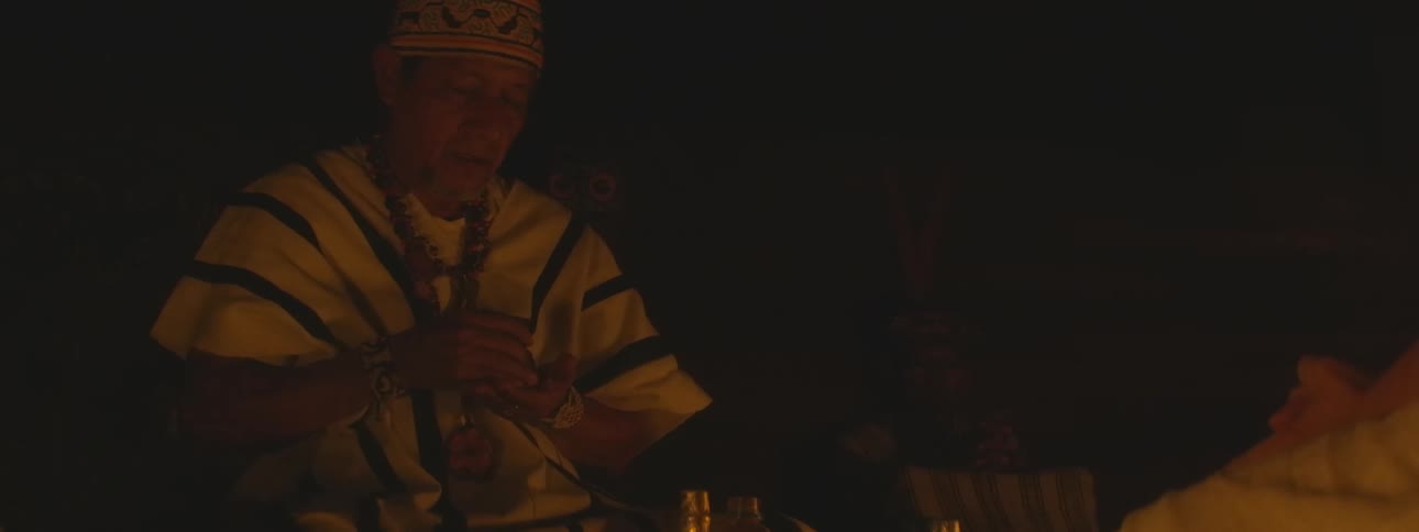 Close up of an indigenous spiritual leader performing a sacred ritual by candlelight