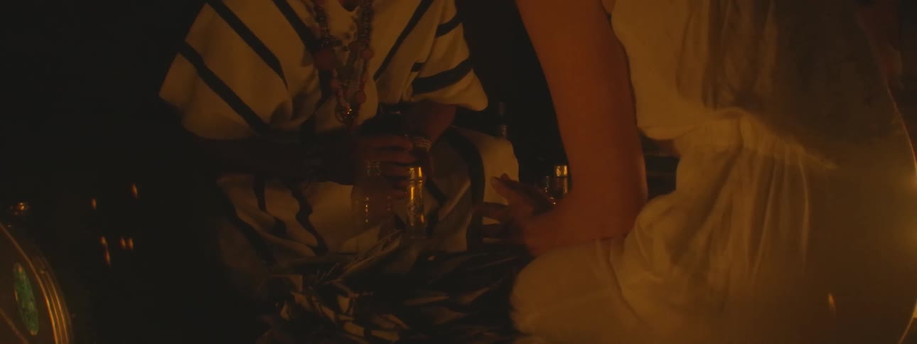 An indigenous shaman leads a woman through a sacred spiritual ceremony by candlelight