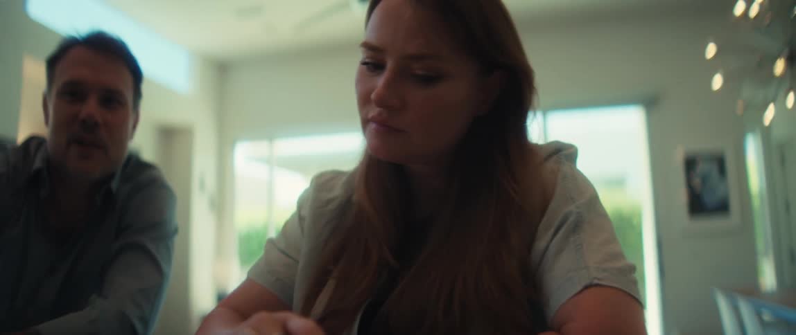 A concerned couple uses a laptop and calculator to manage their finances together in their modern home