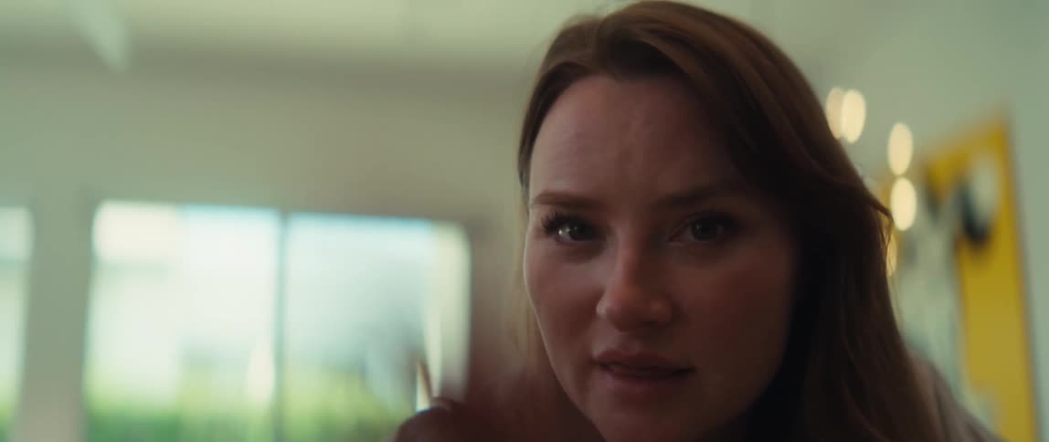 A man and a woman have an animated conversation from a low-angle point of view in a bright, modern home