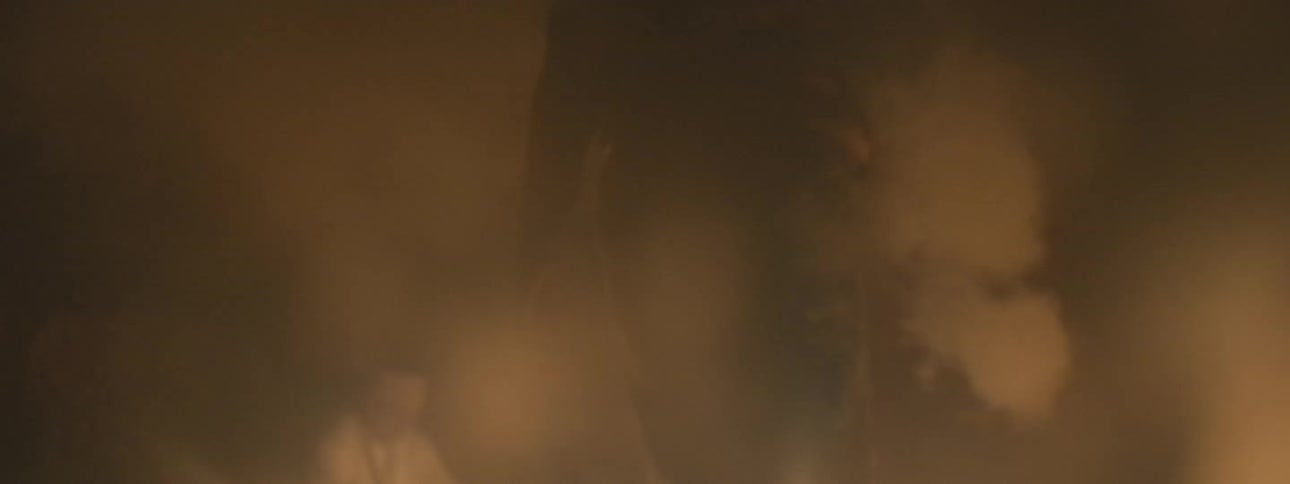 A close up of a mystical ancient ritual with a shaman performing a ceremony in a dark, smoky room lit by candles