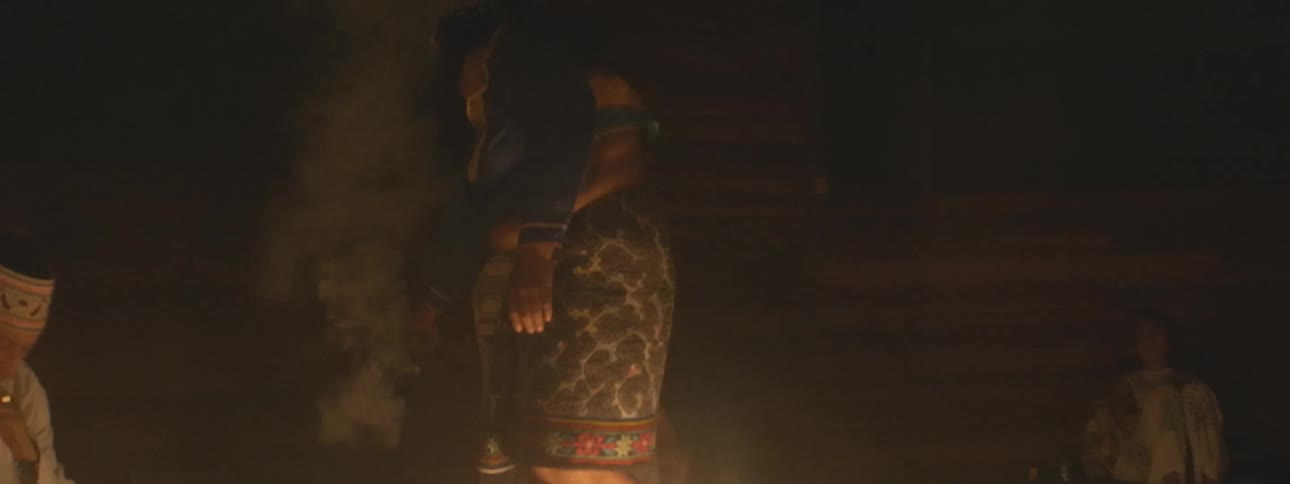 Indigenous shamans perform a spiritual cleansing ritual with smoking incense in a dark, candlelit room