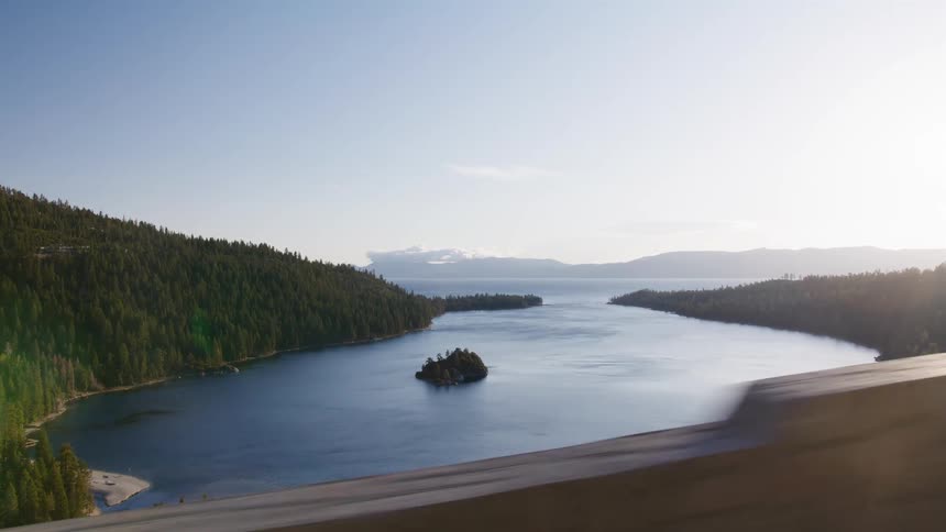 A scenic drive reveals a stunning view of Emerald Bay and Fannette Island in Lake Tahoe on a bright, sunny day