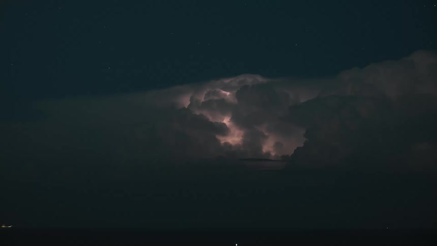 Dramatic time-lapse captures a powerful electrical storm brewing inside dark clouds over the ocean at night