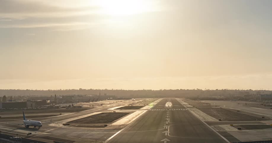 A golden hour timelapse shows constant activity with airplanes landing and taking off on a busy airport runway