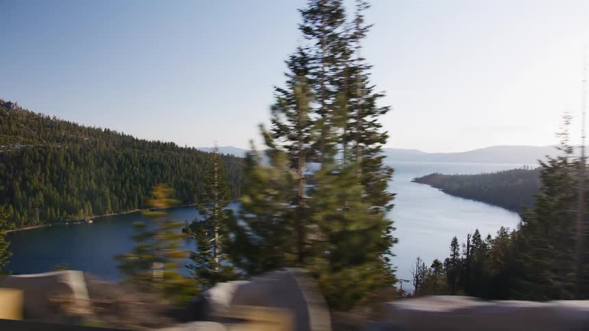 Driving past majestic pine trees on a winding mountain road reveals a breathtaking view of Emerald Bay in Lake Tahoe
