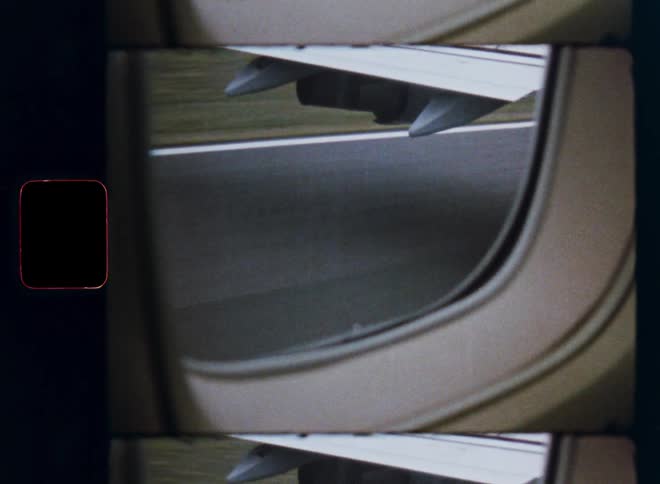 Super 8 film captures a view from an airplane window as it speeds down the runway for takeoff