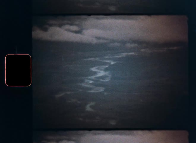 Vintage Super 8 film captures a dramatic aerial view of a winding river through a dark, dense jungle