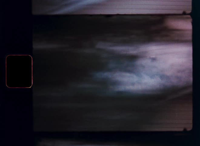 A dreamy, nostalgic view of a foggy mountain forest landscape captured on vintage 8mm film from a moving car