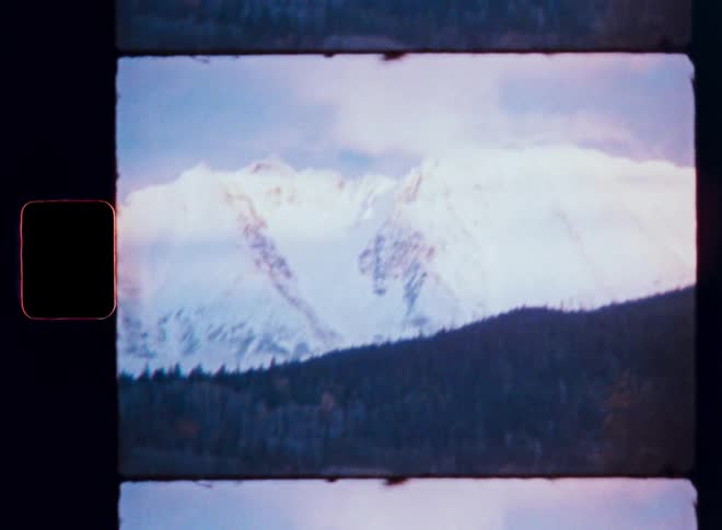 An authentic Super 8mm film scan captures a breathtaking view of a snow-covered mountain range