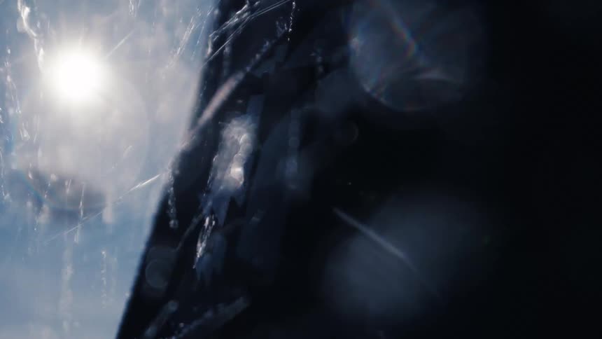 Mysterious and abstract particles swirl in the air, illuminated by a bright sun flare