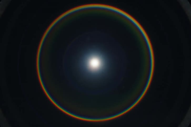 A stunning time-lapse shows a vibrant circular rainbow, or sun halo, glowing around the bright sun