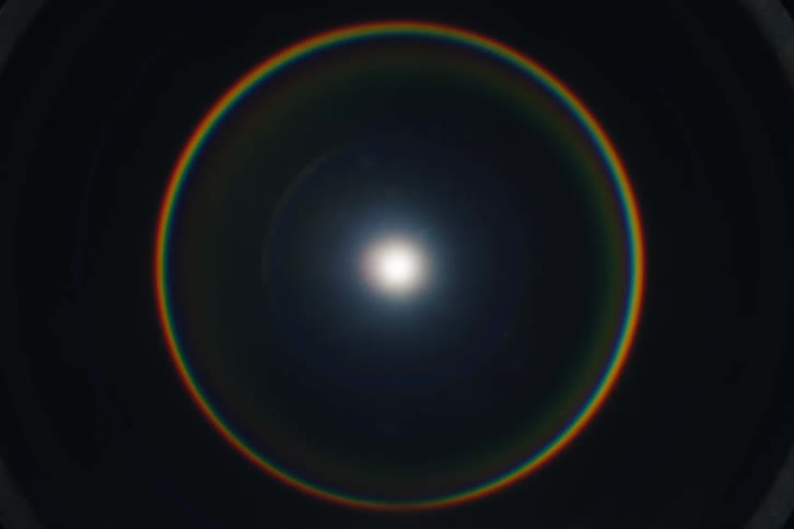 A beautiful sun halo creates a perfect rainbow circle in the sky as the light fades in a time-lapse