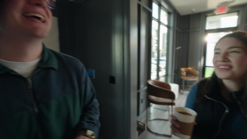 Diverse friends share laughter and conversation over a morning coffee and bagel bar in their apartment community's stylish lounge