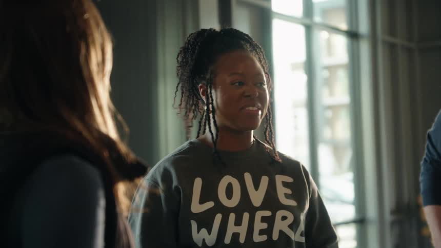 An engaging African American woman shares a laugh and an animated conversation with friends in a beautifully sunlit room