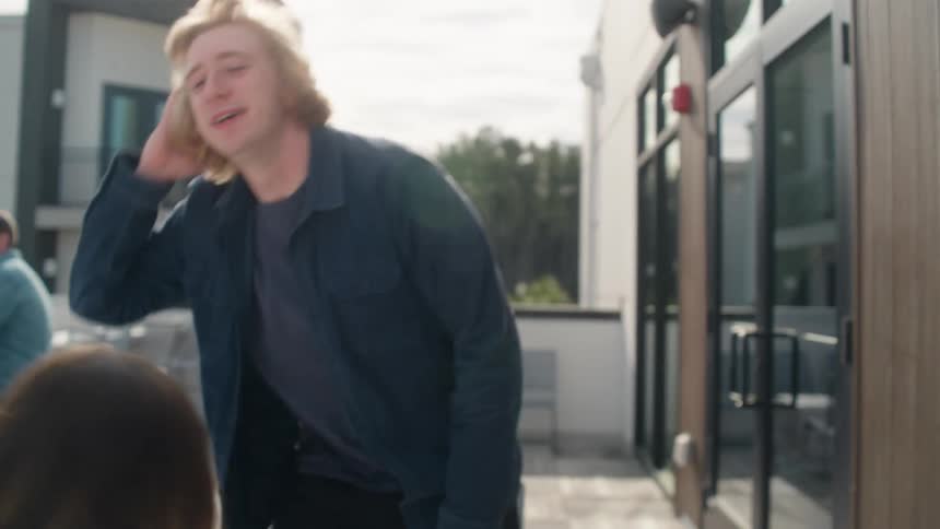 A happy young couple walks out onto a modern patio with coffee and enjoys a fun, engaging conversation in slow motion