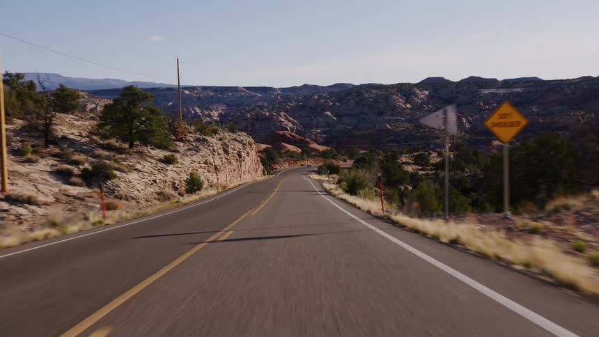 A scenic point-of-view drive along a winding highway through the rugged desert canyons of the American Southwest