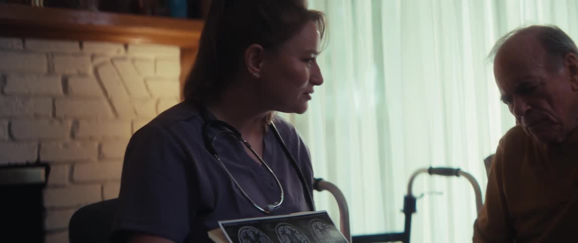A compassionate nurse explains the results of a brain scan to an elderly male patient in a cozy, sunlit room