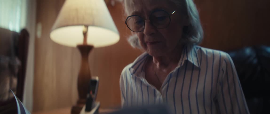 A thoughtful elderly couple reviews healthcare options with a compassionate nurse during a home visit