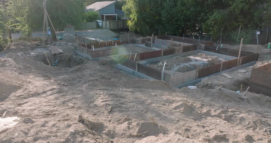 Low push towards a newly poured concrete foundation of a residential home under construction