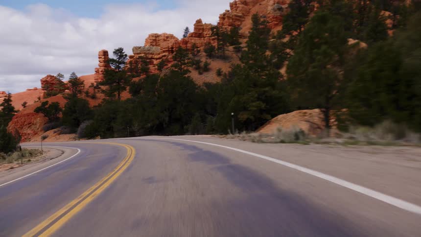 A scenic point-of-view drive along a winding road through the stunning red rock canyons of a national park