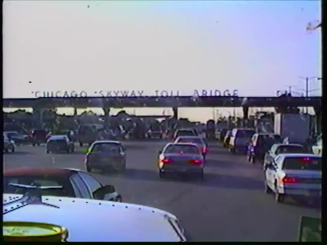 A driver's point-of-view of slow-moving traffic leading up to the Chicago Skyway Toll Bridge on a sunny day