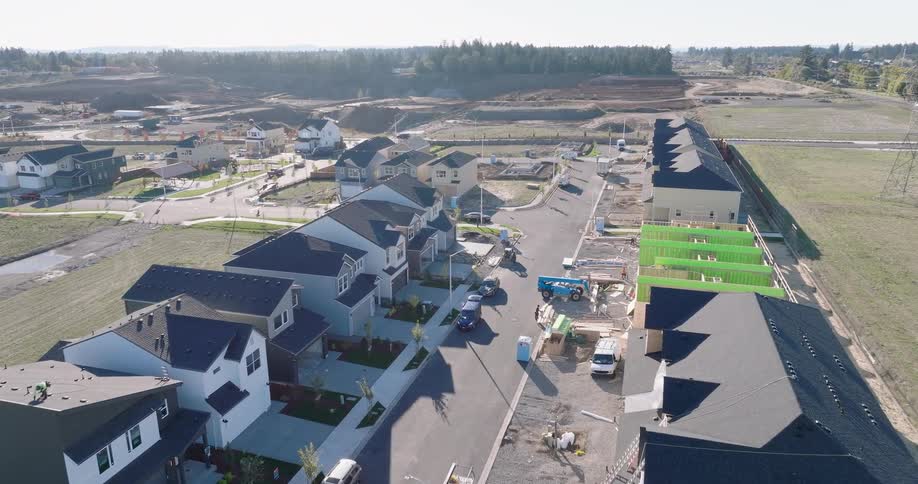 Low push towards a new suburban neighborhood with homes and townhomes in various stages of completion