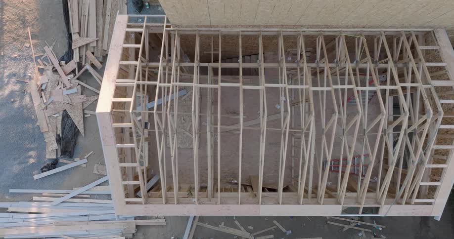 Top down traverse over the intricate wooden framing of a house under construction