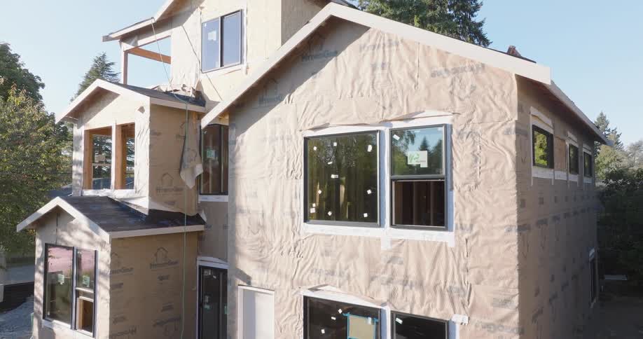 Subtle orbit around a new multi-story residential home during the framing and wrapping phase of construction