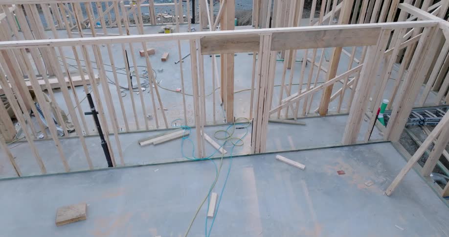 Low skim over wood beams and newly framed walls of a new residential house under construction