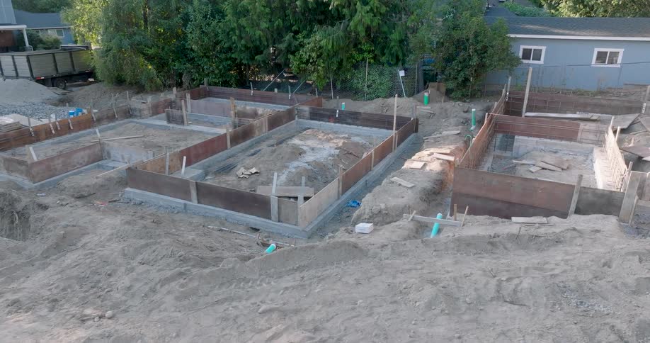 Orbit around a new residential home construction site with foundation forms and footings set in place for a concrete pour