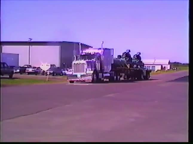 Vintage VHS footage slowly zooms out from a massive semi-truck carrying a heavy industrial load
