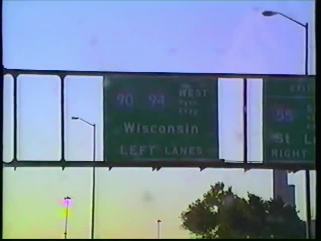 Vintage VHS footage captures a drive along the interstate towards the Chicago skyline at sunset