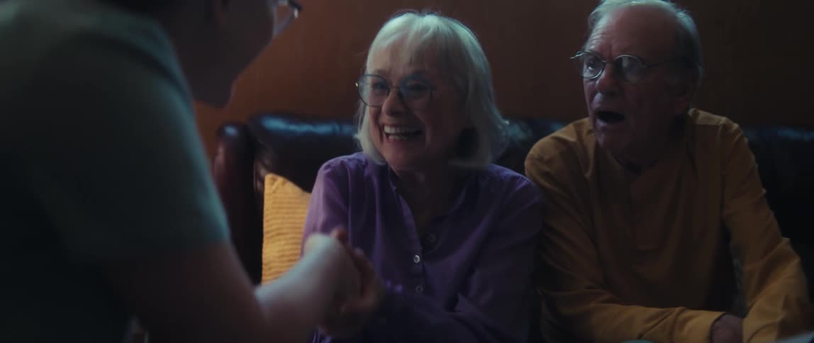 An elderly couple reacts with overwhelming joy and surprise while receiving great financial news from their advisor at home