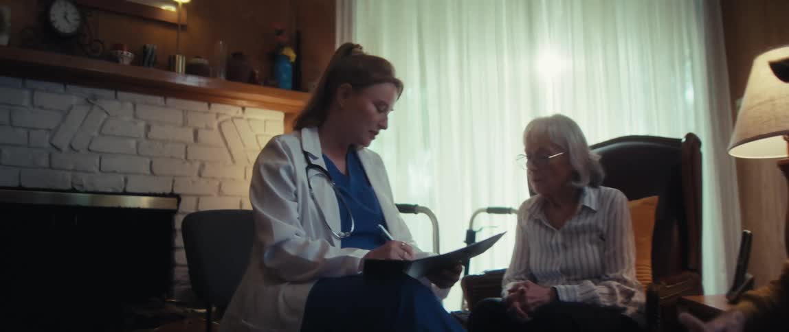 A compassionate home healthcare doctor consults with an elderly couple in their living room, offering personalized medical advice