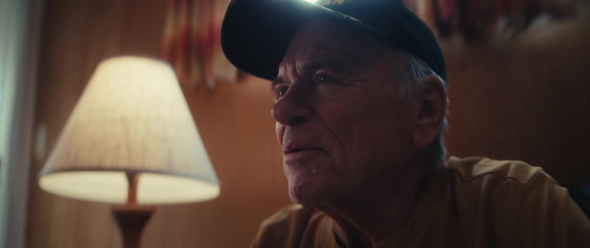 A Vietnam veteran shares an emotional memory as his wife listens lovingly during an interview at home