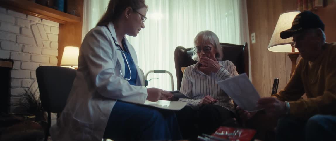 A doctor visits an elderly couple at home to review medical results, causing the wife to become sad and emotional
