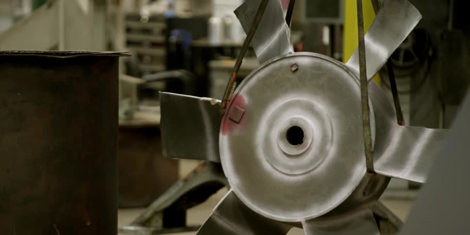 A man walks in a shop with metal equipment