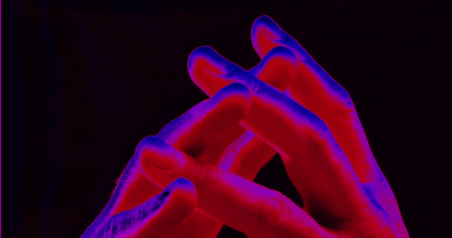An abstract thermal vision close-up of intertwined hands nervously twitching with red and blue coloring