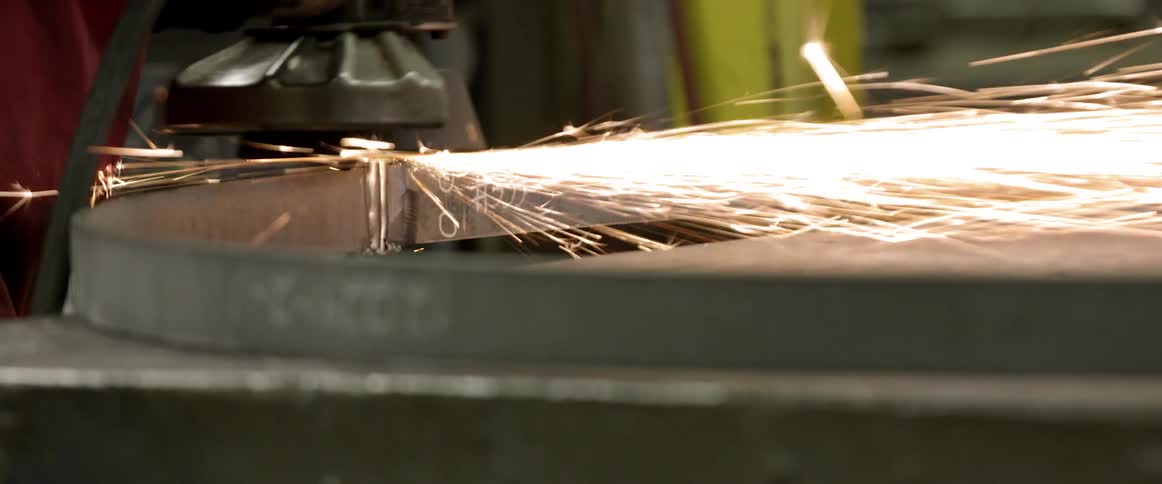A grinding wheel causes sparks to shoot out from the metal surface