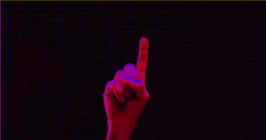 A hand with its index finger pointing up to gesture the number one is illuminated by red and blue lights against a dark background