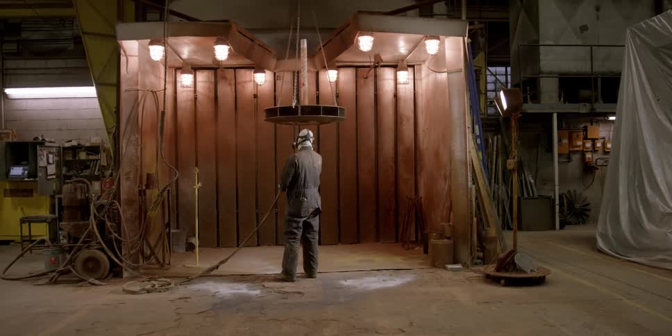 A worker is spray painting in a workshop