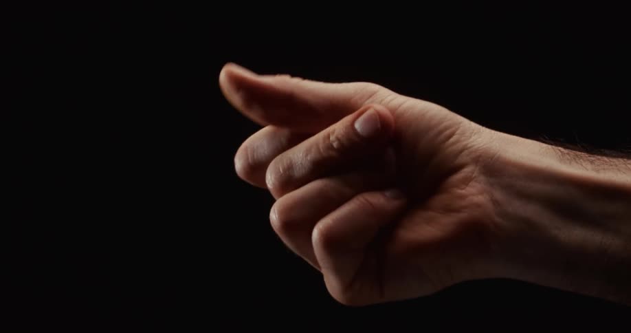 A close-up shot of a man snapping his fingers in slow motion against a black background