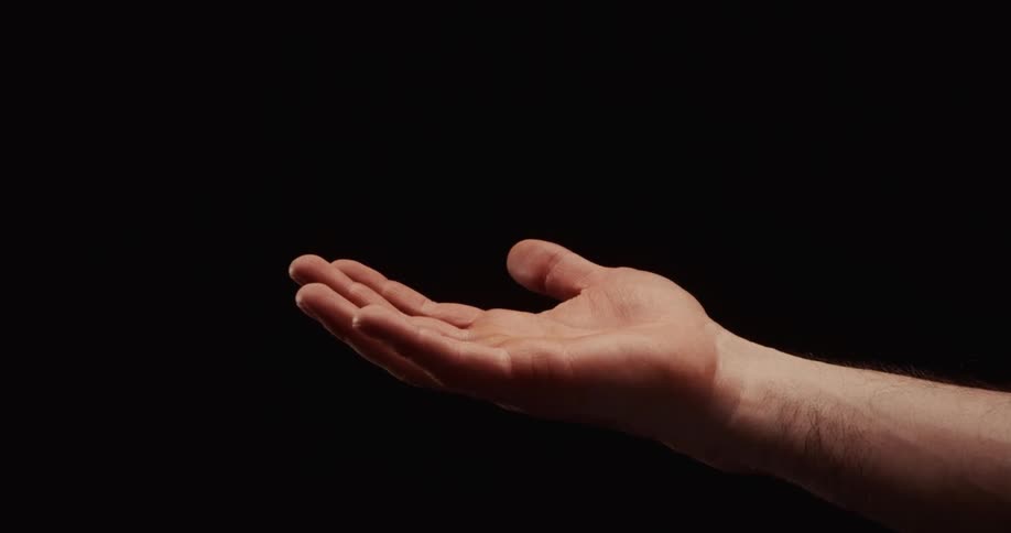 Slow motion footage shows a man's fist slowly opening into a welcoming, open palm against a stark black background