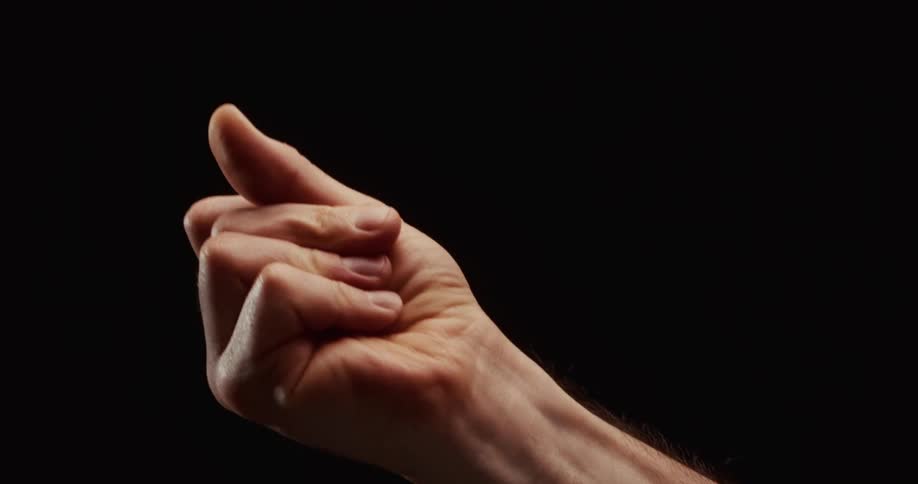 A man's hand dramatically lit against a black background makes a quintessential Italian gesture and then beckons