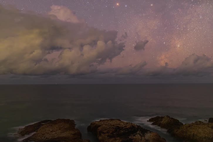 Breathtaking timelapse of a lightning storm rolling over the ocean horizon as the Milky Way appears in the starry night sky