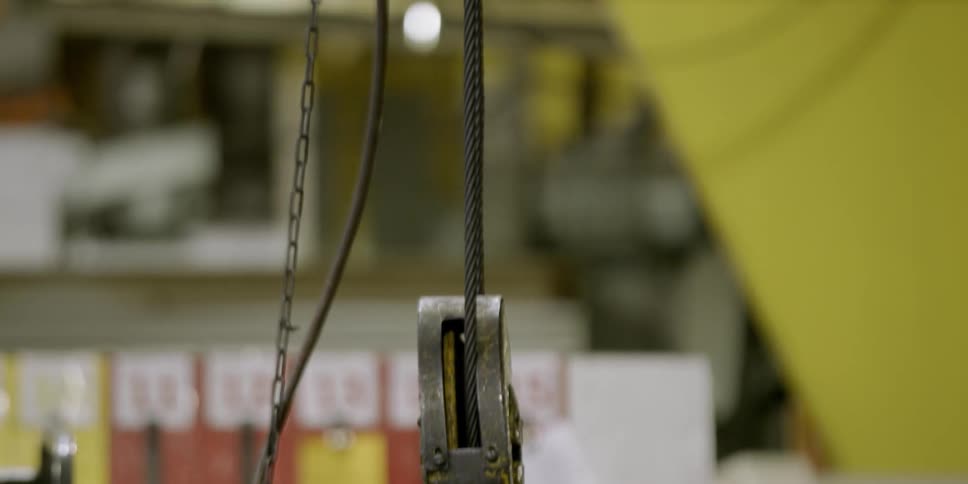 A metal hook hangs in a factory
