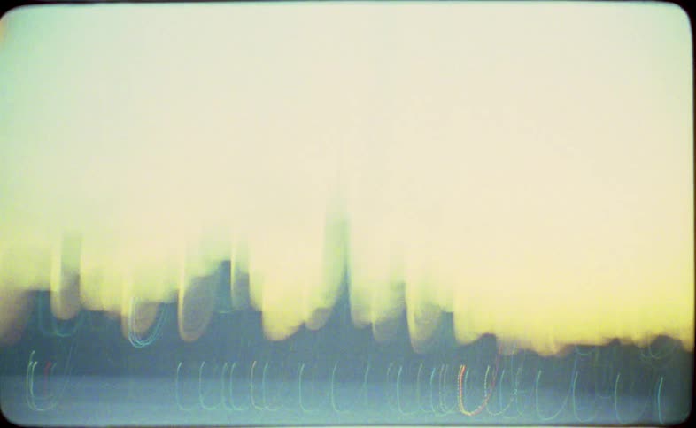 A dreamy, abstract view of the New York City skyline at twilight captured on vintage film with streaks of light